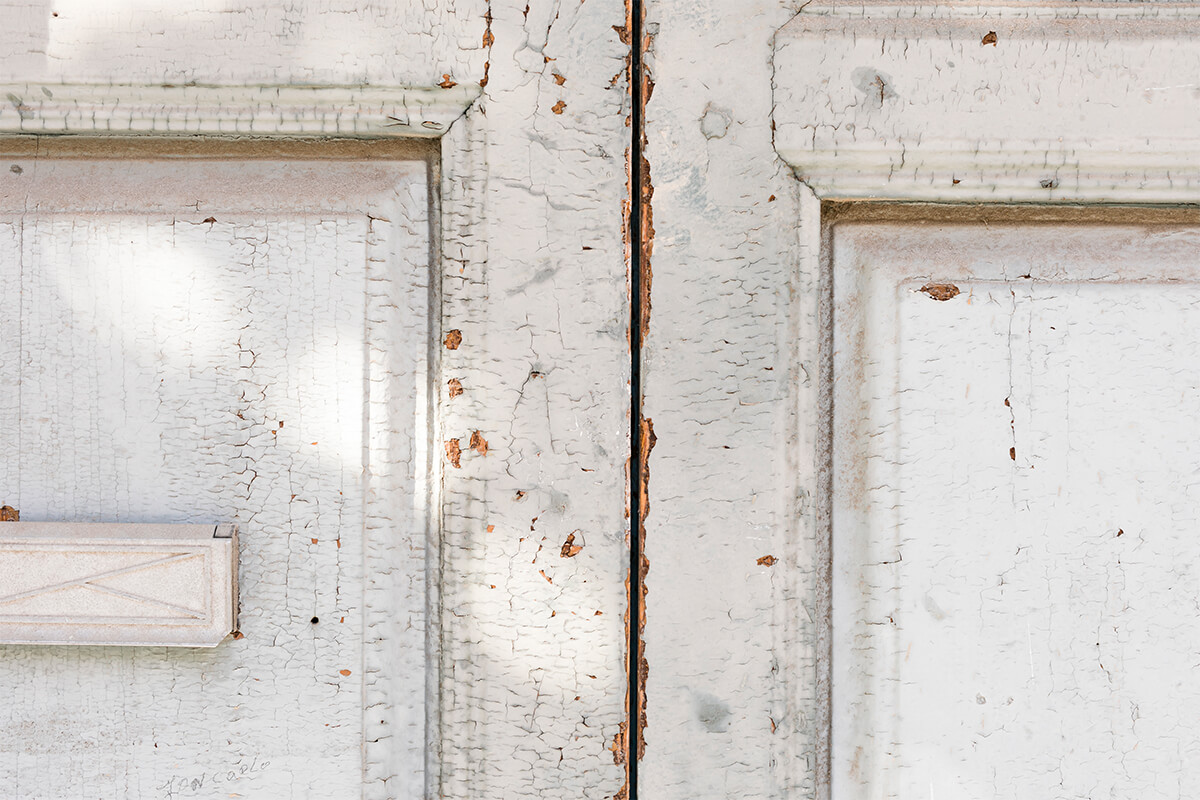 What determines how often a wood door needs refinishing?