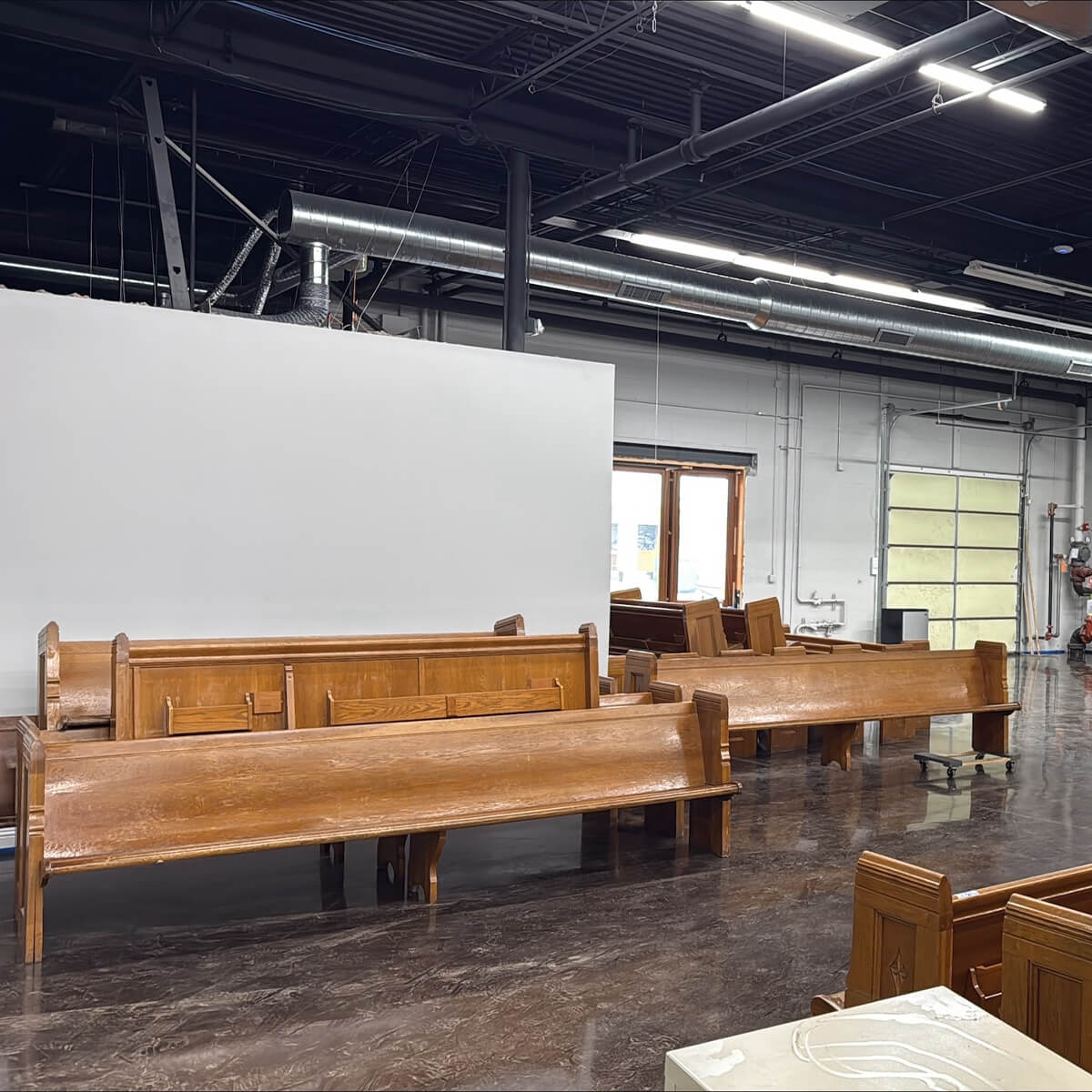 Pews refinishing in warehouse by Scobis